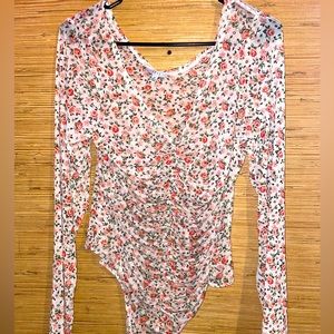 Woman’s white see-through body suit with roses